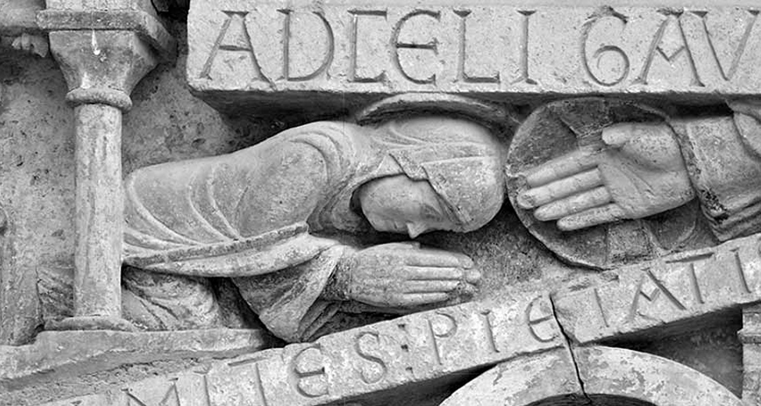 Prosternation de sainte Foy, mains jointes devant la main de Dieu. Cette même posture d'humilité se retrouve sous les traits d'un moine du tympan de l'abbaye de Mozac (Puy de Dôme).